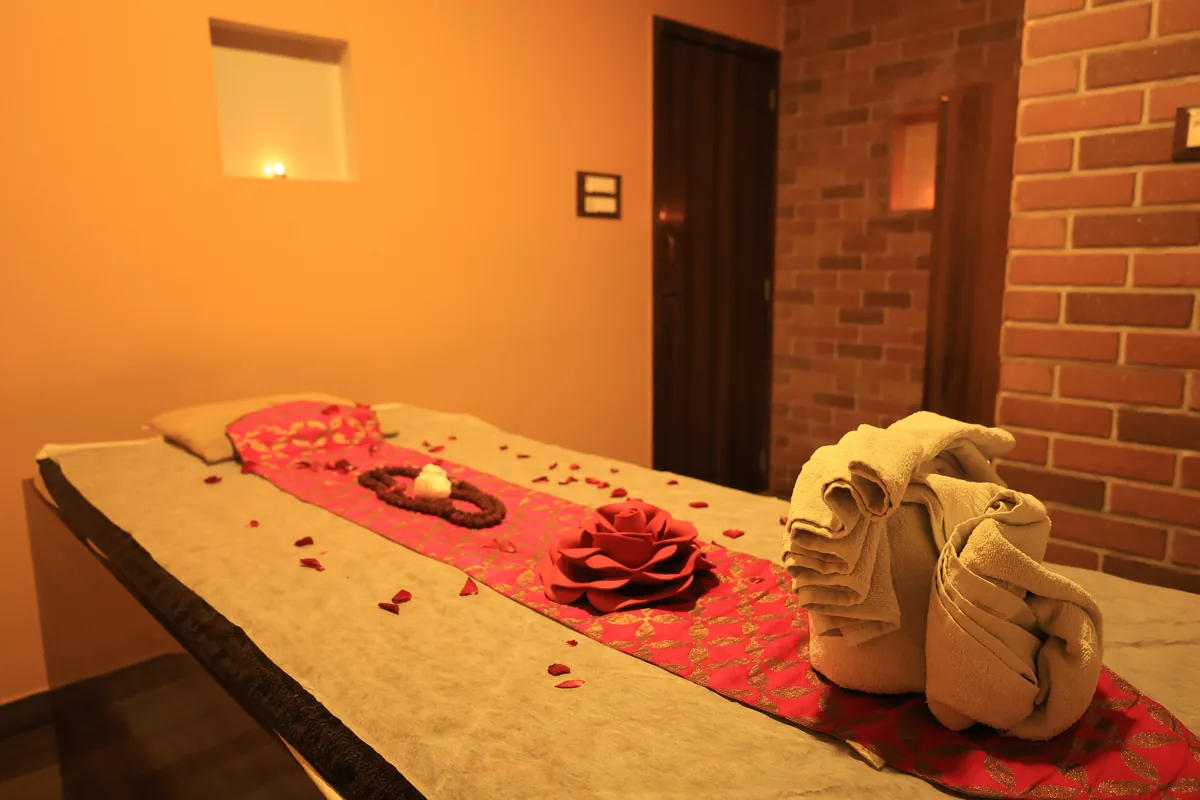 Massage bed prepared with fresh towels and rose petals at Inara Spa, Mira Road